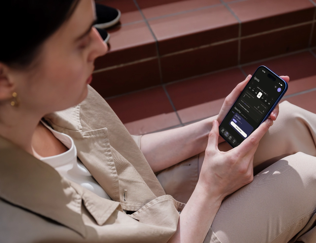 Une professionnelle consulte l'agenda de son salon dans l'application mobile Bookelya Pro